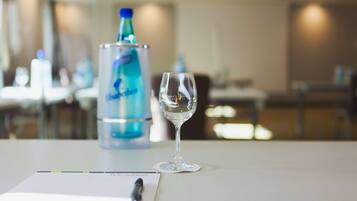 Une table avec un verre d’eau, une bouteille d’eau et un bloc-notes avec un stylo.