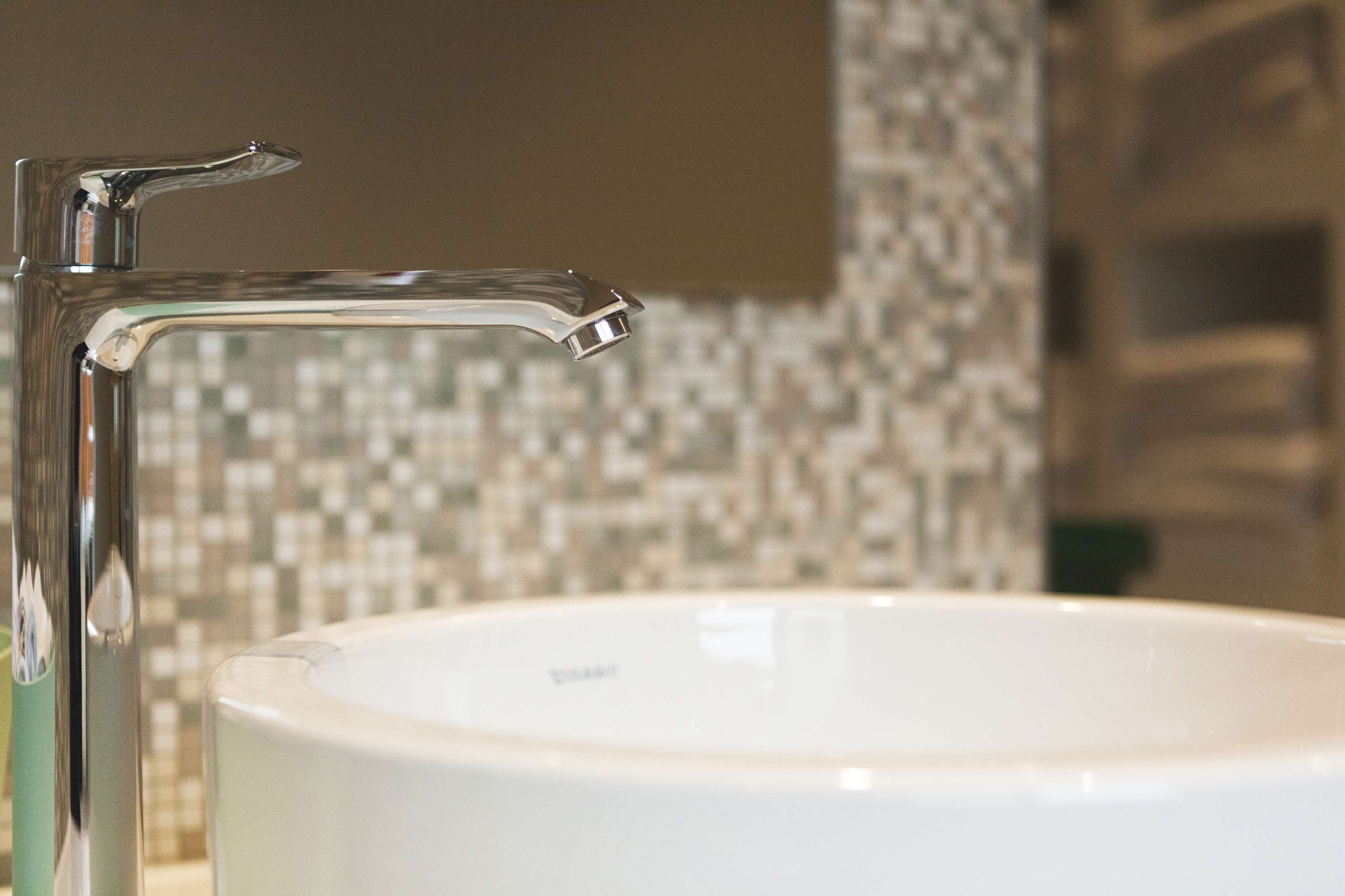 A bathroom with a white sink and a chrome faucet.