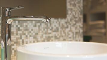 A bathroom with a white sink and a chrome faucet.