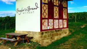 Un edificio pequeño con un letrero que dice "Biegler & Brand WEINGUT" y una mesa de picnic al frente.
