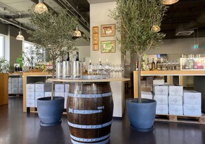 Una tienda de vinos con barricas de madera, botellas y copas.