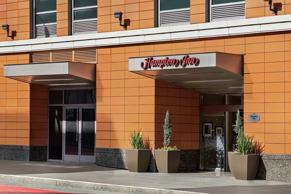 The exterior of Hampton Inn with a modern design, featuring a prominent entrance and large planters with greenery. - Hampton Inn San Francisco Downtown/Convention Center (San Francisco)