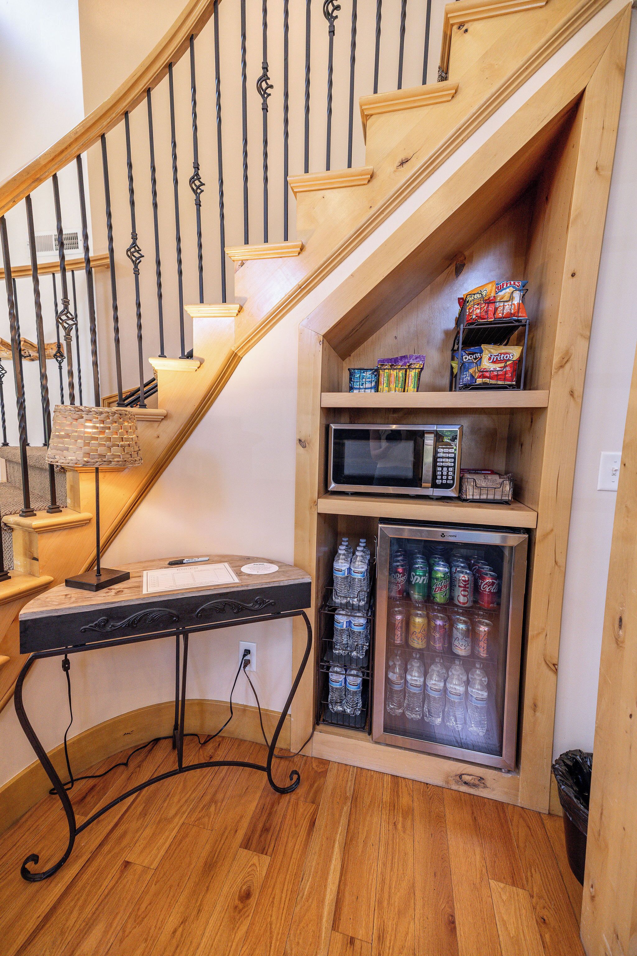 Un escalier en bois, avec un four à micro-ondes et un réfrigérateur placés en dessous.