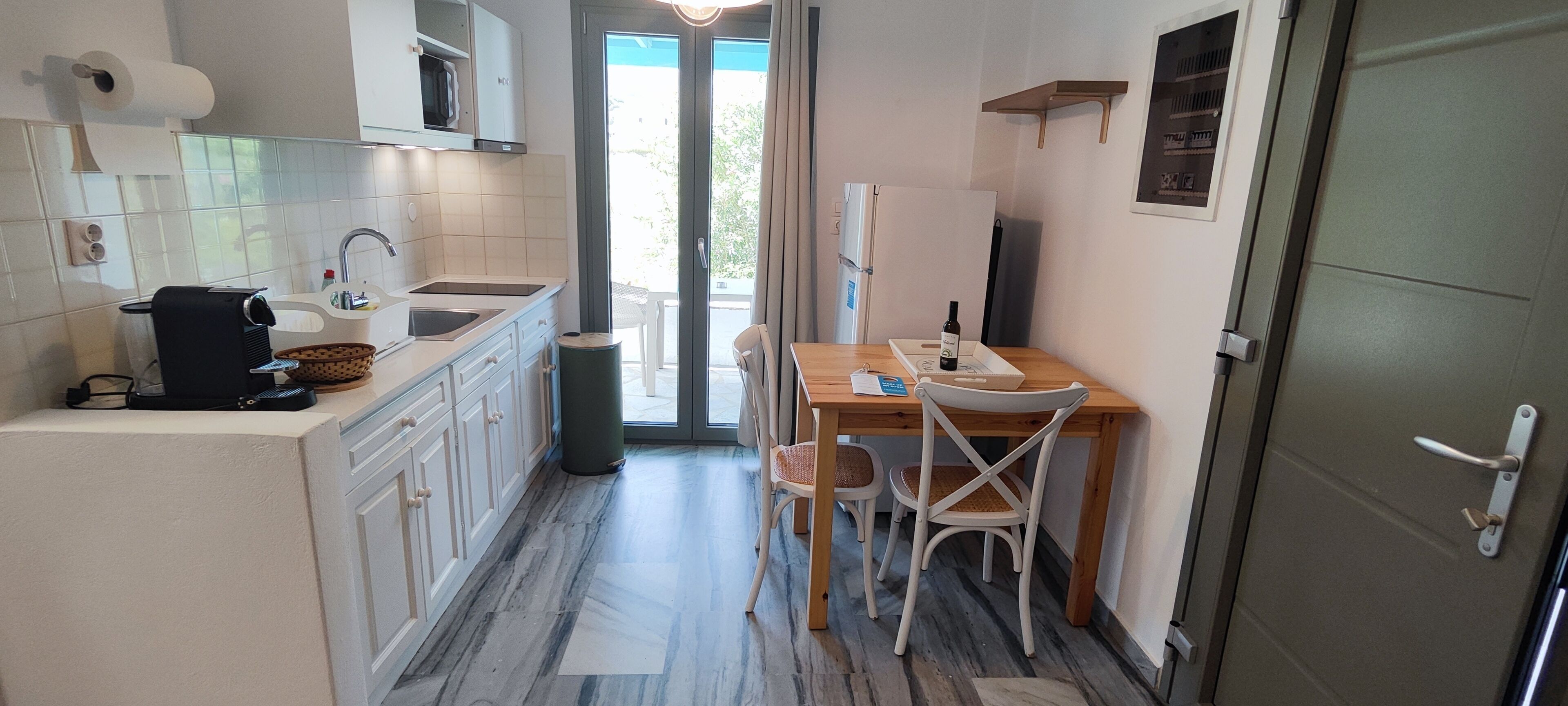 Una cuina compacta amb un rentapeus, fogó i zona de menjador amb caires.