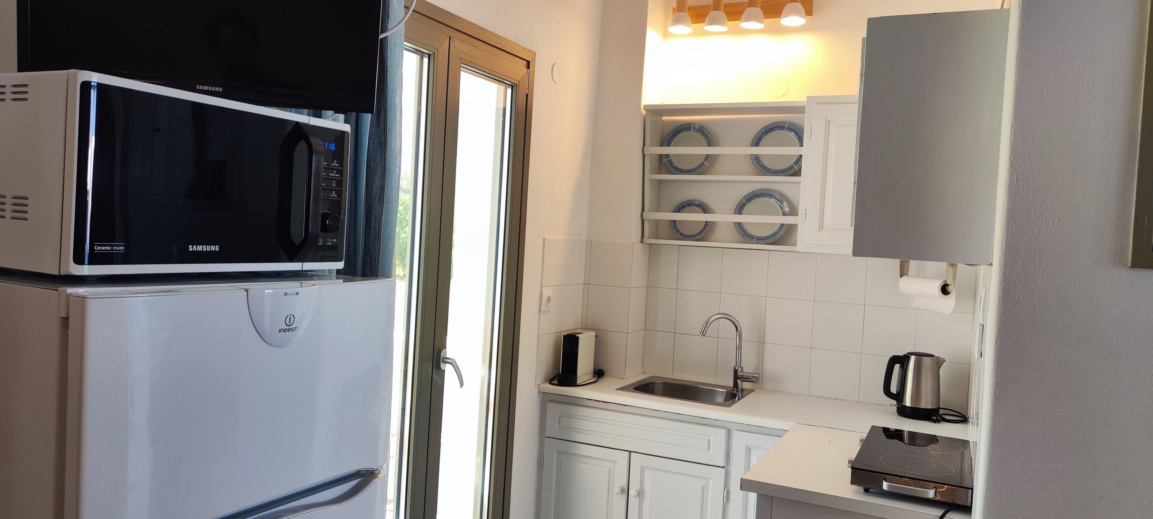 Une cuisine compacte équipée d’un four à micro-ondes, d’un grille-pain, d’une bouilloire et d’un évier.