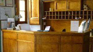 Una reception in legno con un portatile, documenti e una piccola pianta.