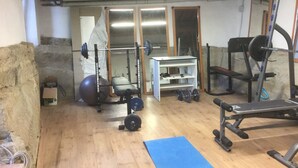 Una palestra in casa con panca per pesi, rack per squat e palla da ginnastica.