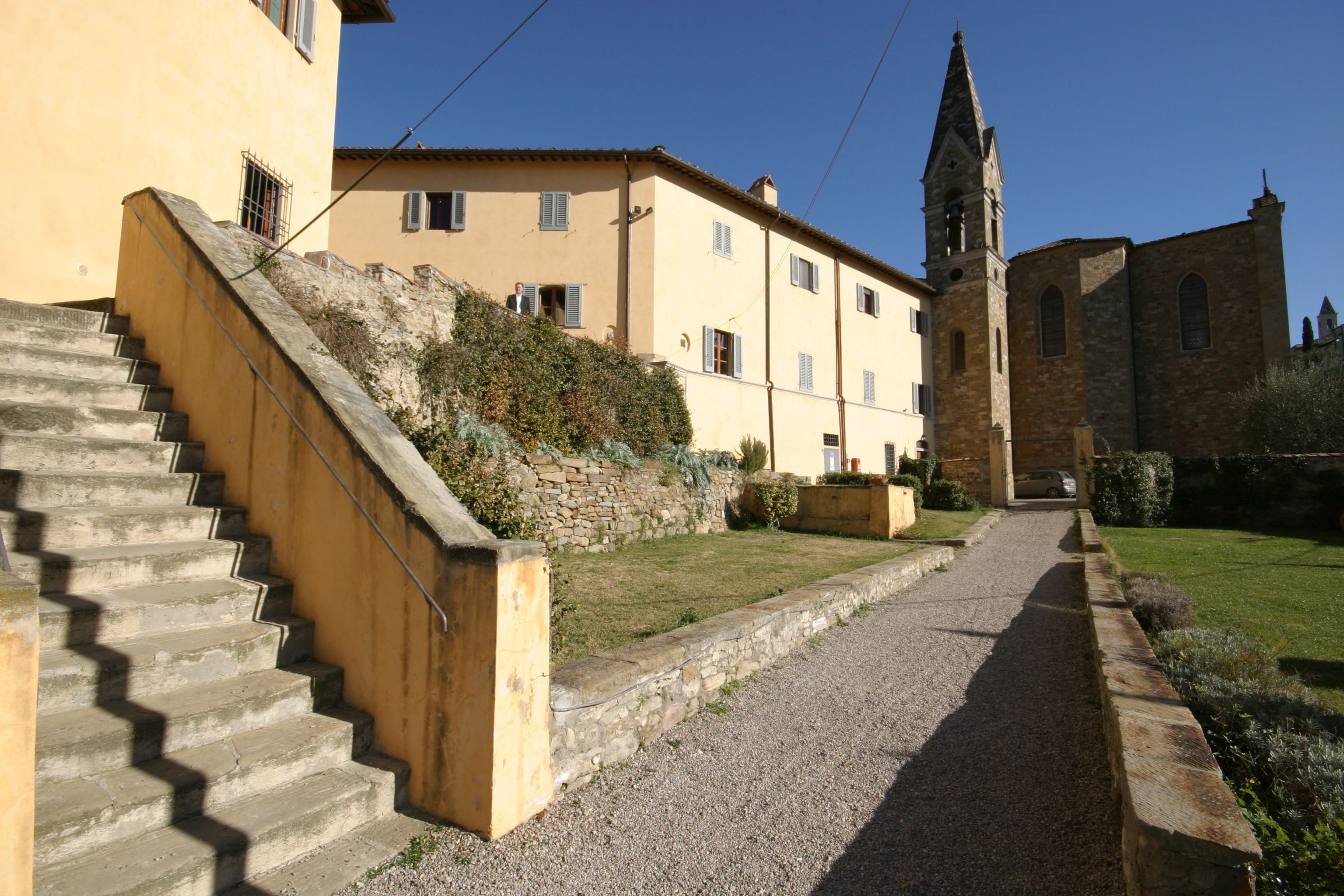 A stone staircase leading to a building with a church tower.