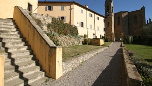 Una scala in pietra conduce a un edificio con una torre campanaria.