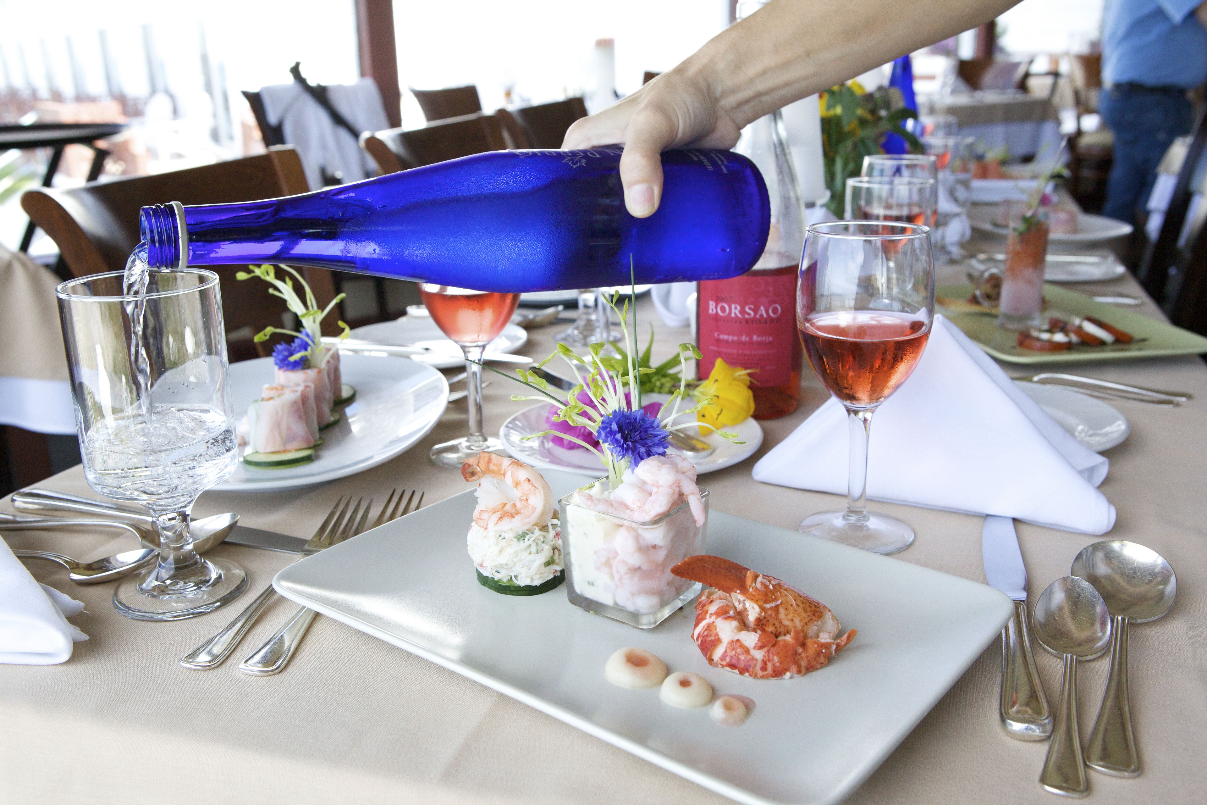 Una mesa de comedor dispuesta con platos, vasos y cubiertos.