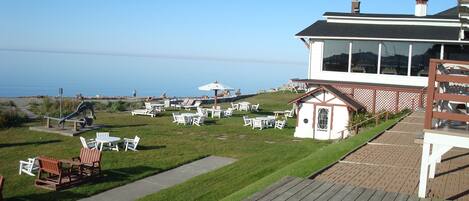 A coastal property with a deck, outdoor seating, and a view of the ocean.