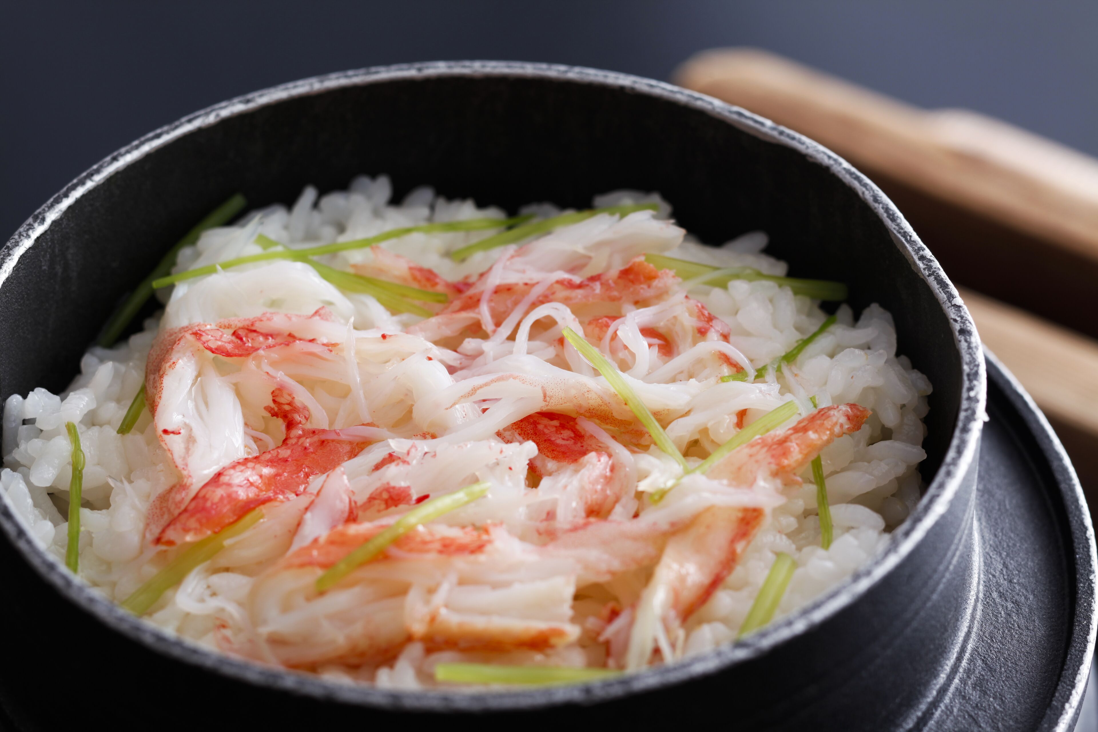 A bowl of rice with crab and green onions.