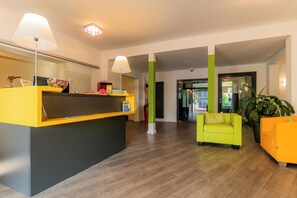 A reception area with a desk, chairs, and a potted plant. - Parkhotel Bad Rehburg (Rehburg-Loccum)