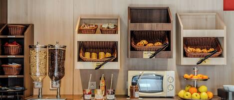 Espaço de buffet de café da manhã com diversas opções de alimentos e acompanhamentos.