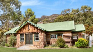 A log cabin with a green roof, stone walls, and a stone staircase leading to the entrance. - Discovery Parks - Halls Gap (Halls Gap)