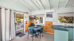 A modern kitchen with a round table, wooden cabinets, and large windows. - Discovery Parks - Halls Gap (Halls Gap)