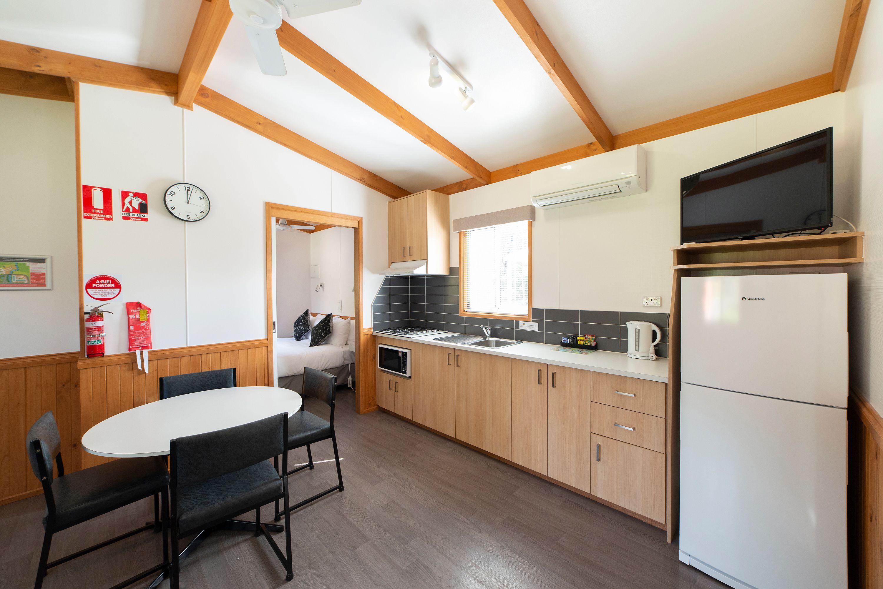 Eine moderne Küche mit Holzbalken, einem weißen Kühlschrank, einem Herd und einem Spülbecken.