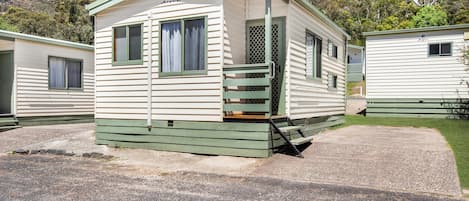 A single-story mobile home with a porch and a small set of stairs leading to the entrance.