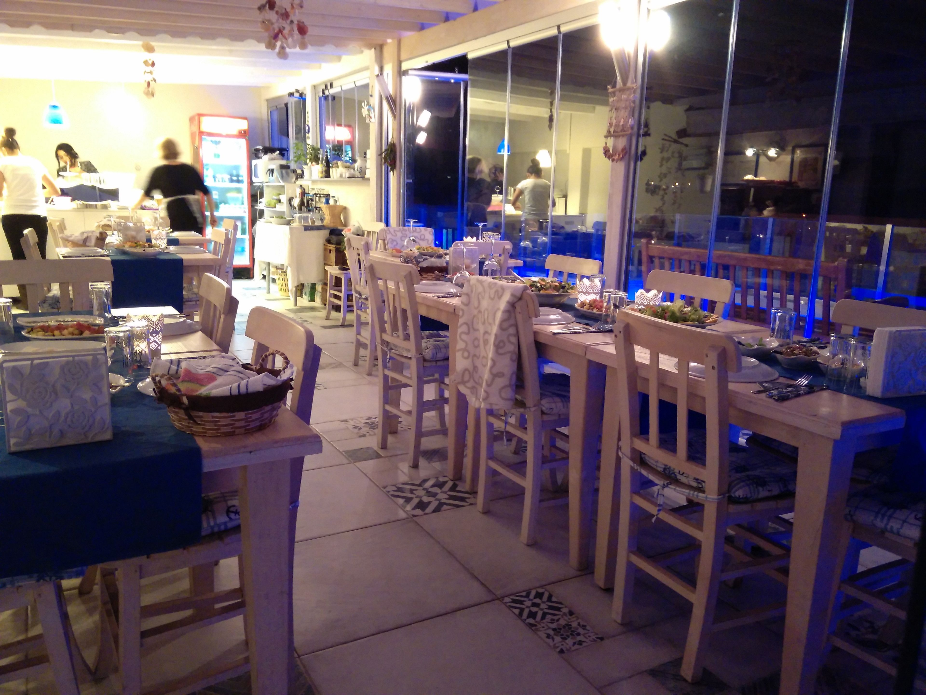 Comedor con mesas y sillas de madera, una barra libre y vistas a través de amplios ventanales.