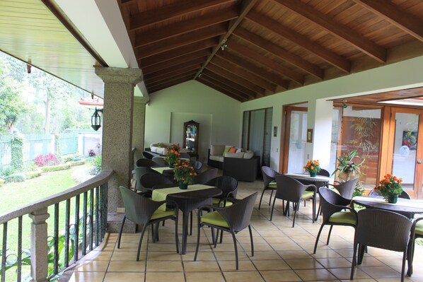 A covered outdoor seating area with wicker furniture and potted plants. - Terrazas de Golf Boutique Hotel (La Asunción)