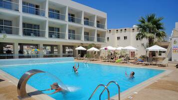 Een seizoensgebonden buitenzwembad en parasols bij het zwembad