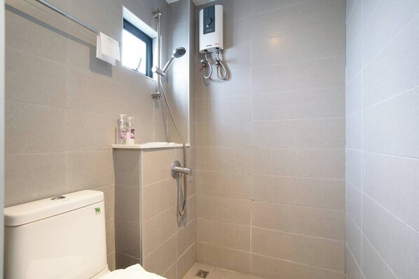Un baño pequeño y moderno con inodoro, ducha y ventana.