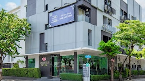 Een modern hotel met een groot bord, een duidelijke ingang en een parkeersignaal.