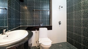 Een badkamer met een witte wastafel, toilet en douche.