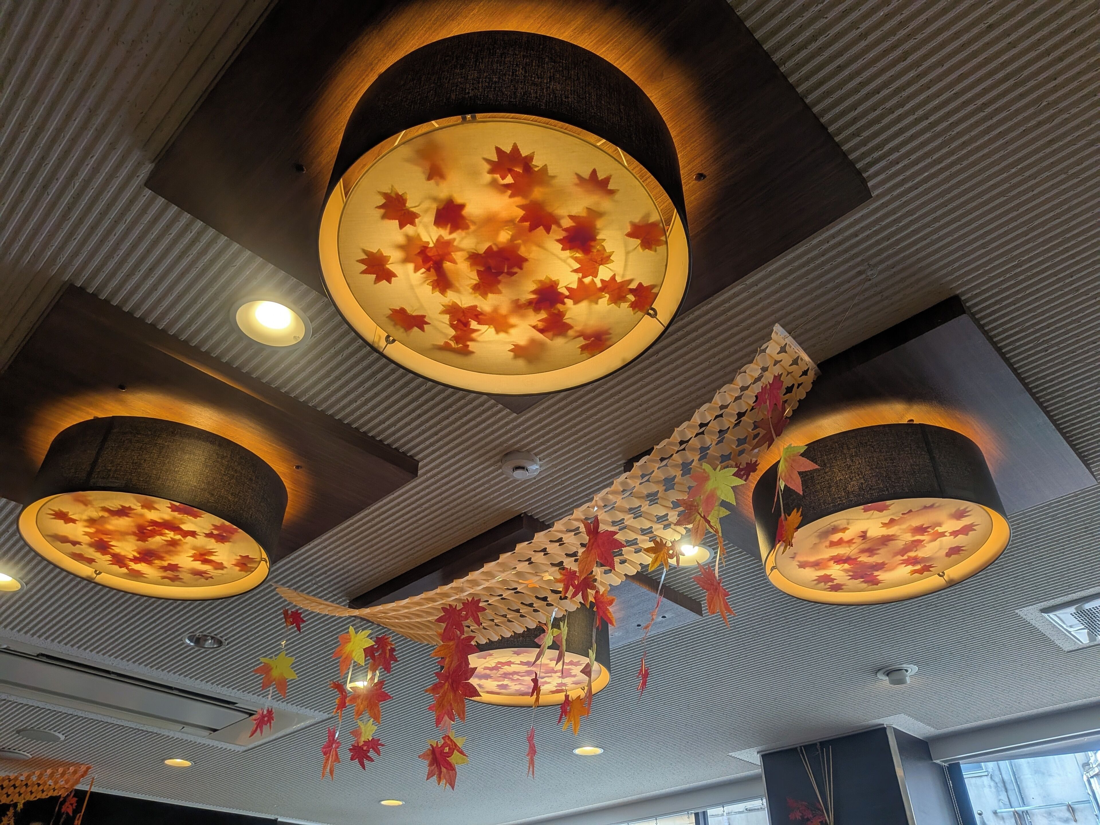 Een plafond met ronde lampen en hangende decoraties.