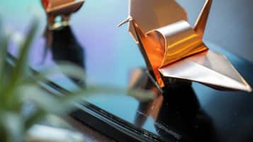 Dos aviones de papel origami sobre una superficie reflectante.
