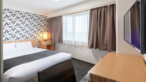 A hotel room with a bed, a desk, a TV, a lamp, and a window with curtains. - APA Hotel Maebashieki-Kita (Maebashi)