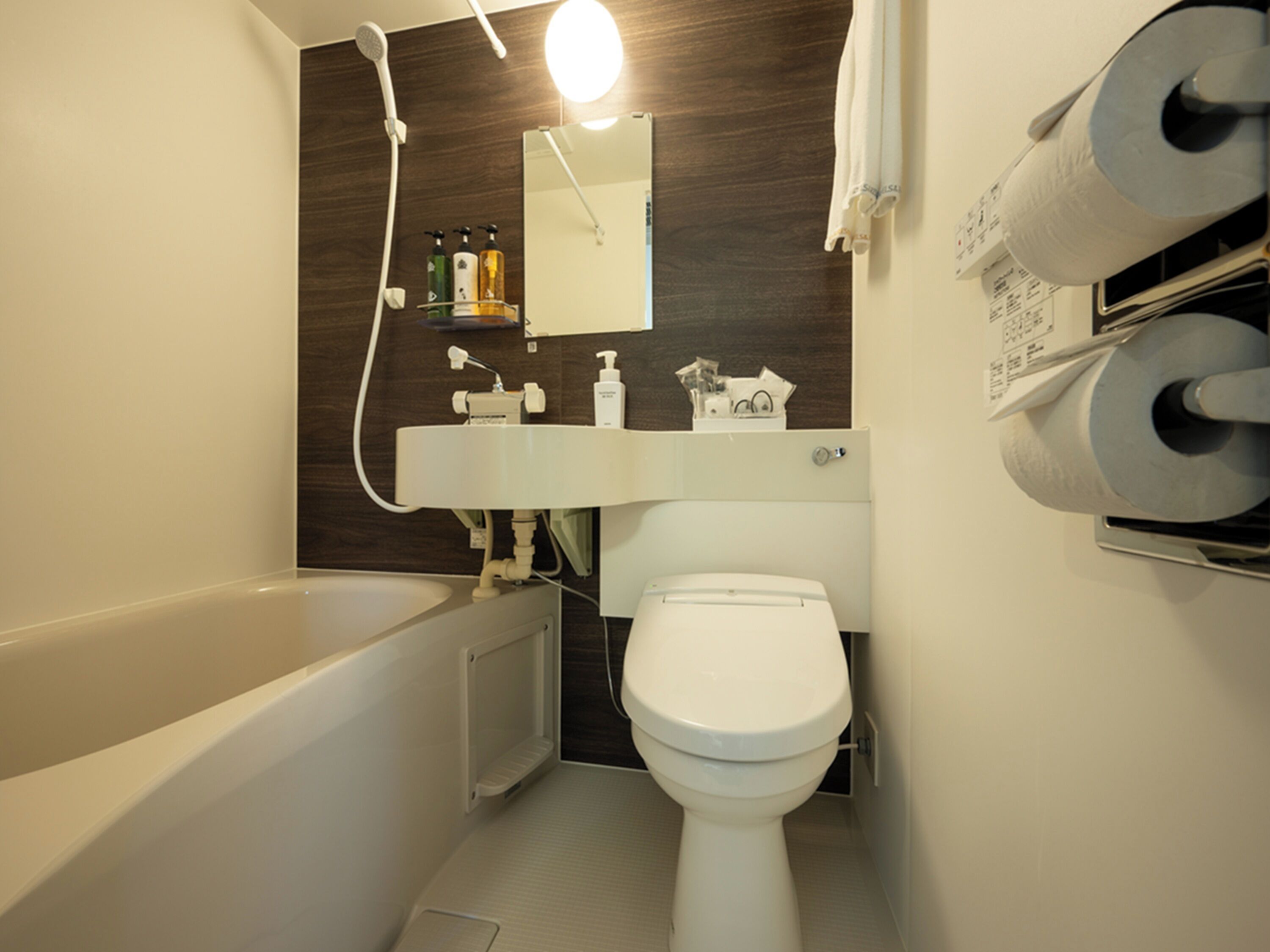 A modern bathroom with a bathtub, toilet, and a shower.