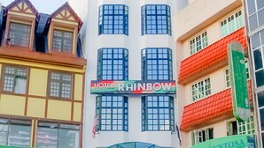 Een meerlaags gebouw met een bord waarop Hotel Rainbow staat.