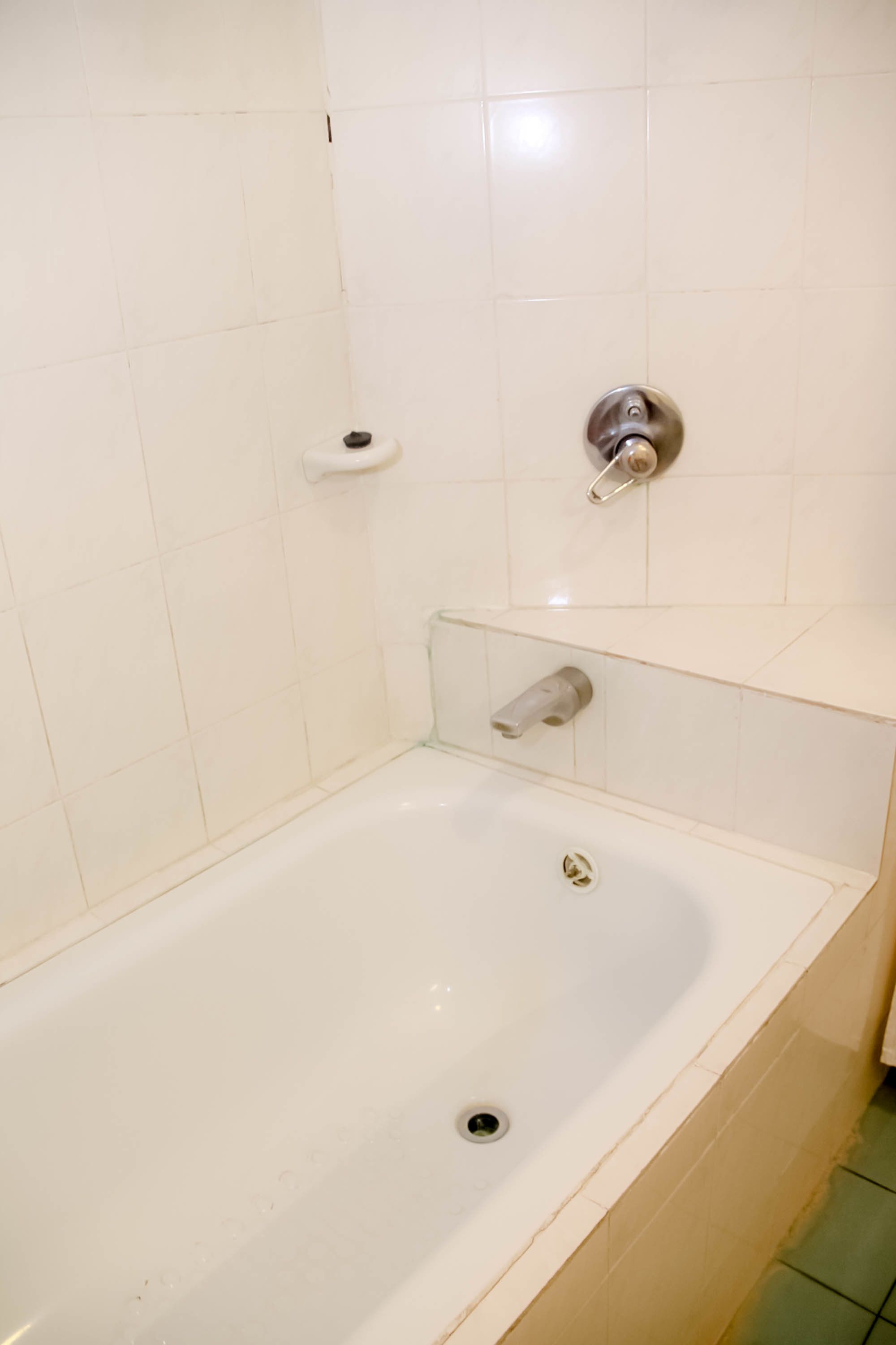 A bathroom with a white bathtub, a toilet, and a shower area.
