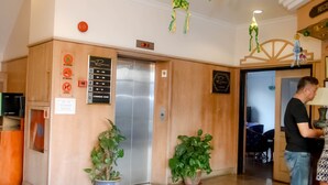 Een lift met een digitaal scherm, een Wi-Fi-bordje en een bord dat een vergaderzaal aangeeft.