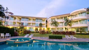 Alberca al aire libre, sombrillas en la alberca y camastros