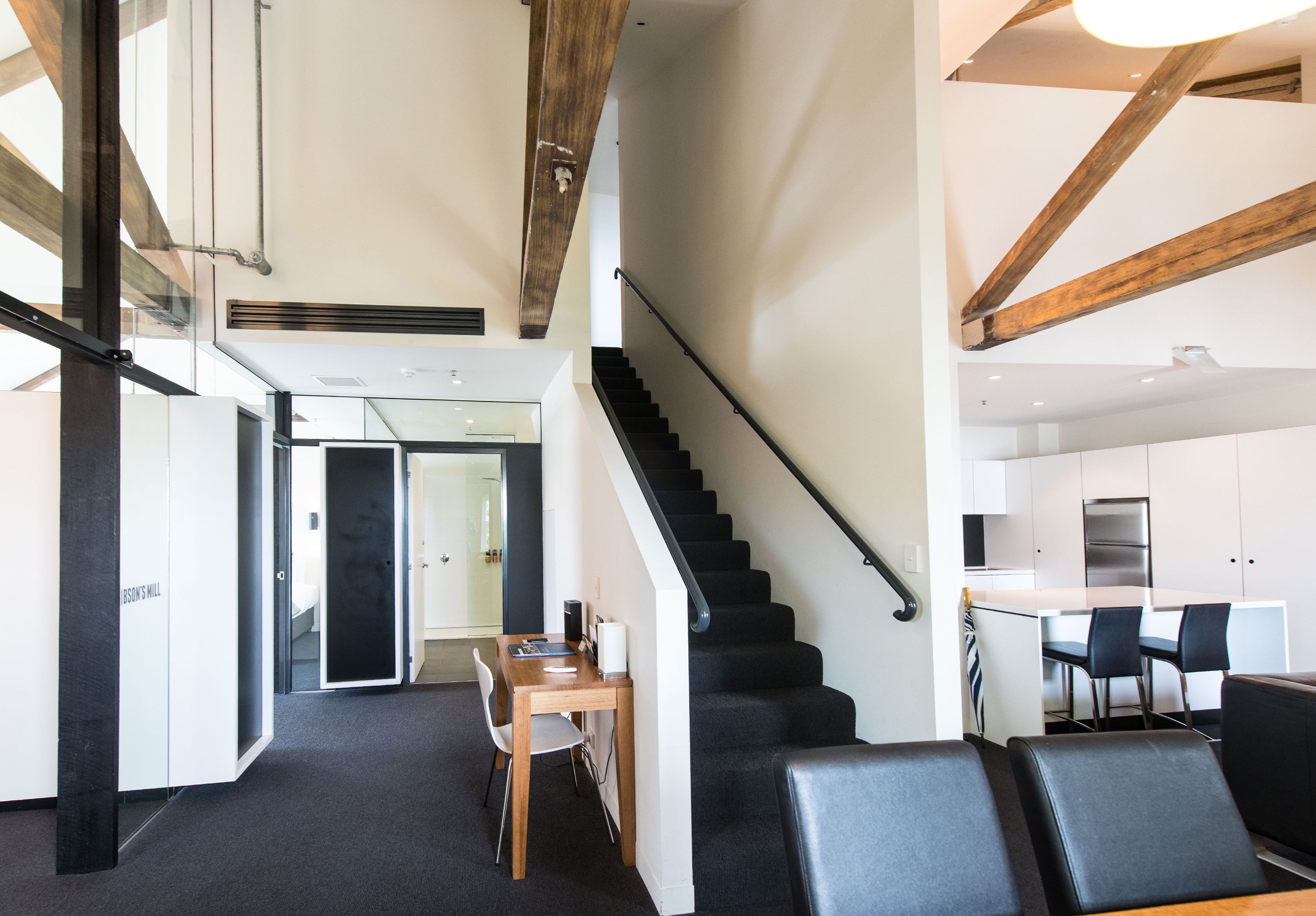 A modern interior with a staircase, a dining area, and a kitchen.