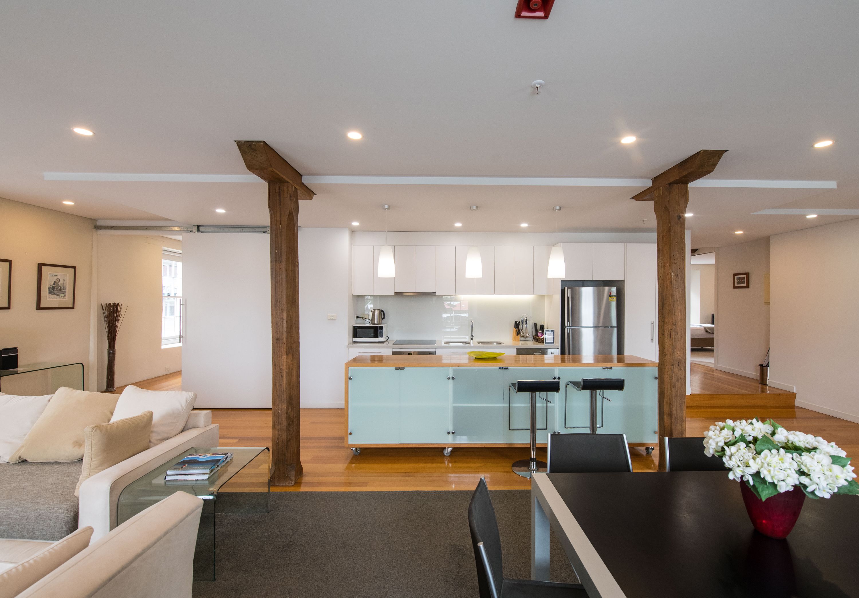 A modern kitchen with white cabinets, a central island, and pendant lighting.