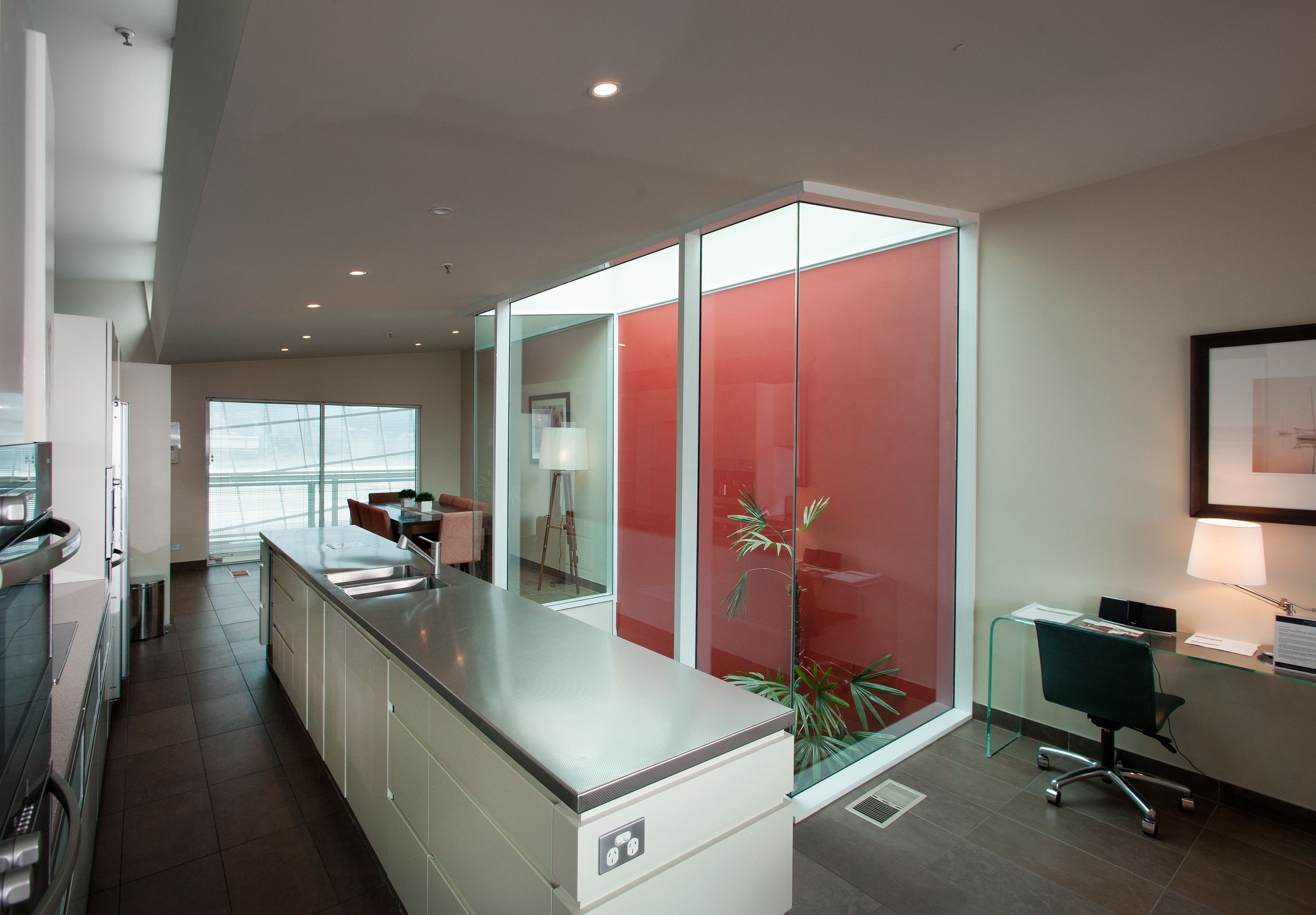 A modern kitchen with a stainless steel countertop, a built-in oven, and a sink.