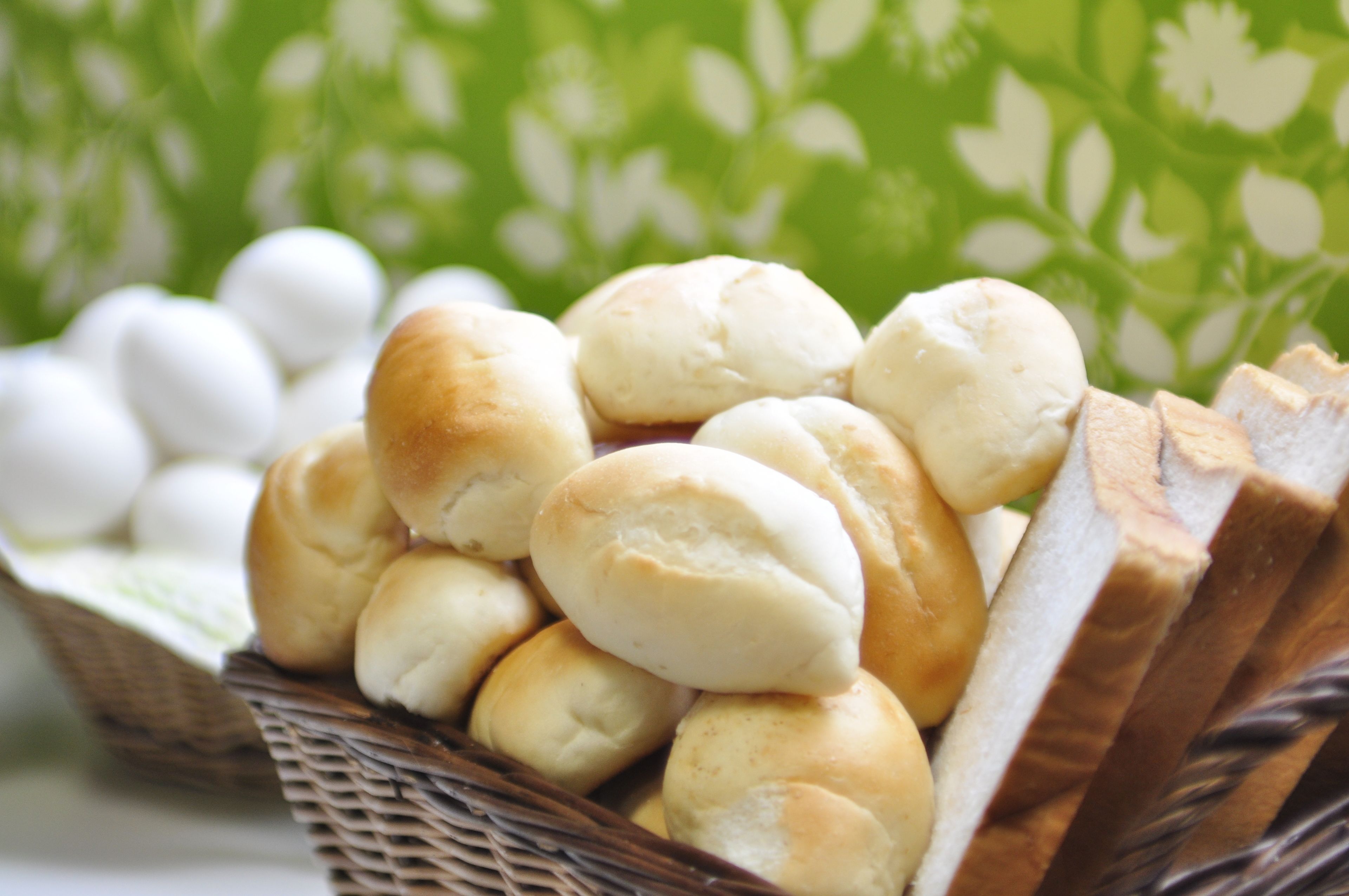 A basket of bread rolls and a loaf of bread.