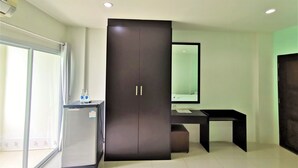 A modern room with a dark wardrobe, a small desk, and a mirror. - Hua Hin Irooms Hotel (Hua Hin)