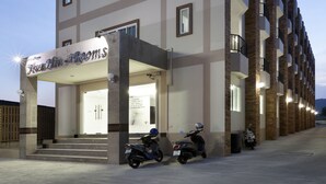 A multi-story hotel with a sign reading "Hotel Min-Rooms" and a row of parked scooters in front. - Hua Hin Irooms Hotel (Hua Hin)