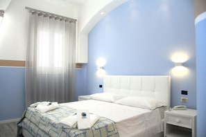 A hotel room with a bed, a nightstand, a telephone, and a window with curtains. - Hotel Città Bella (Gallipoli)