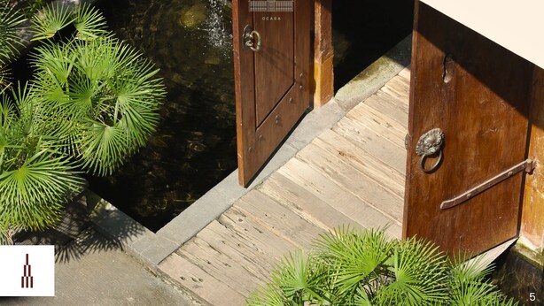 A wooden door with a metal handle and a plaque, a wooden deck, and green plants. - Bale Ocasa (Tangerang)