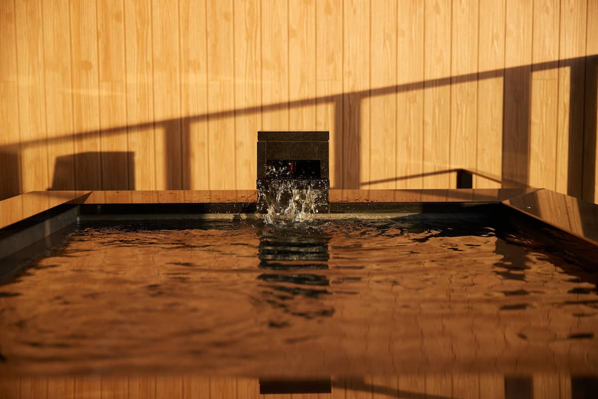 A wooden interior with a water feature and a small window.