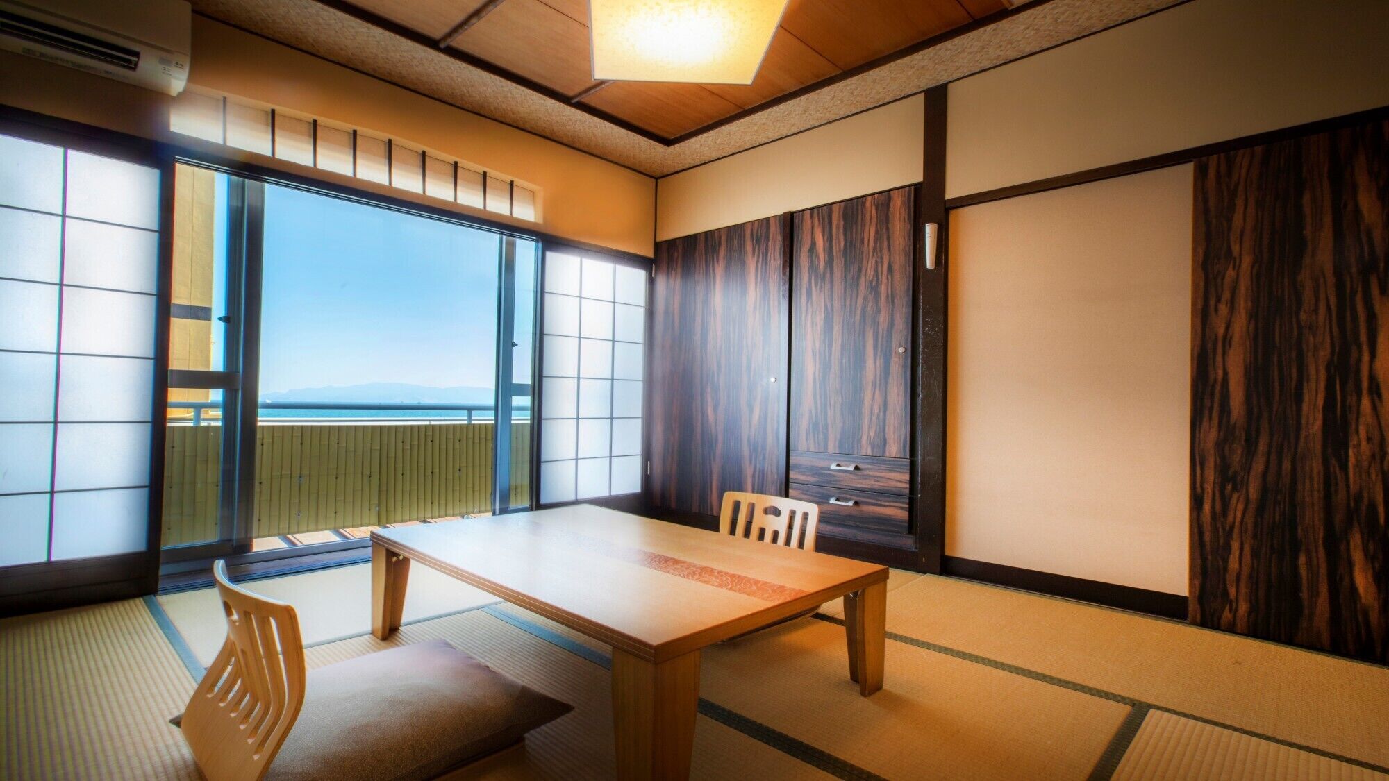 A traditional Japanese room with tatami flooring, a low table, and sliding doors.