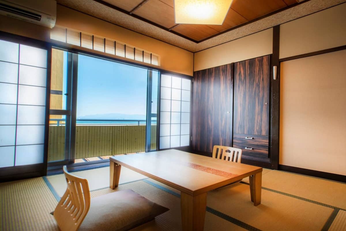 A traditional Japanese room with tatami flooring, a low table, and sliding doors.