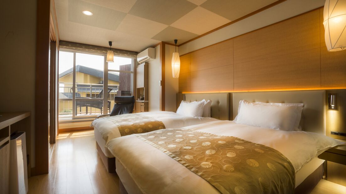 Habitación de hotel con una cama grande, un escritorio y vista a un edificio.