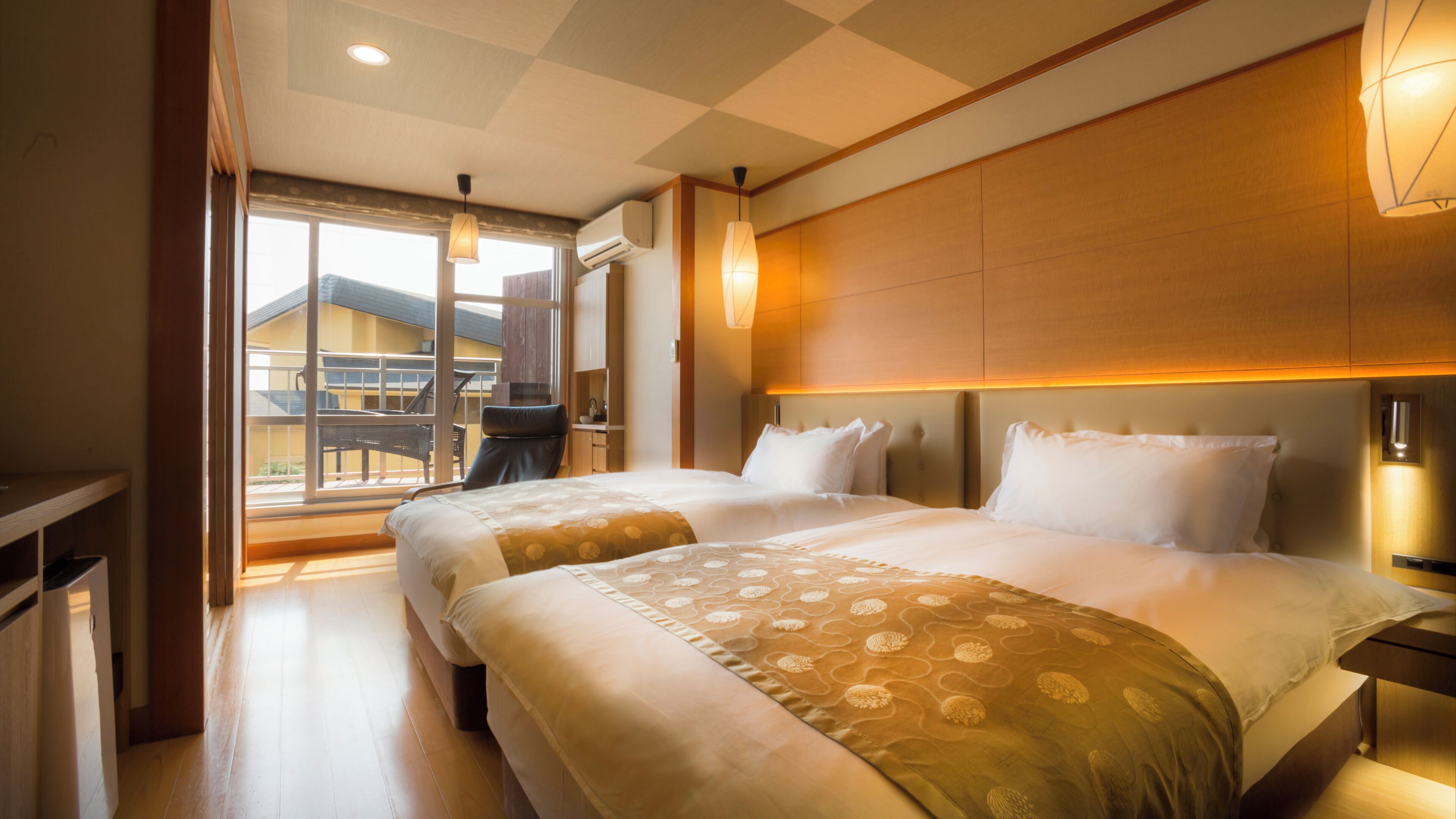 Habitación de hotel con dos camas, un balcón y vistas a un edificio.