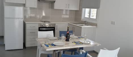 A modern kitchen with white cabinets, a built-in oven, and a window above the sink.